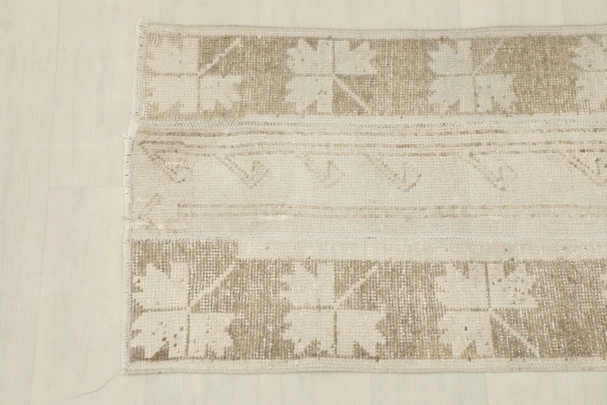 Overhead shot of the rug's bottom half, highlighting the tan geometric patterns