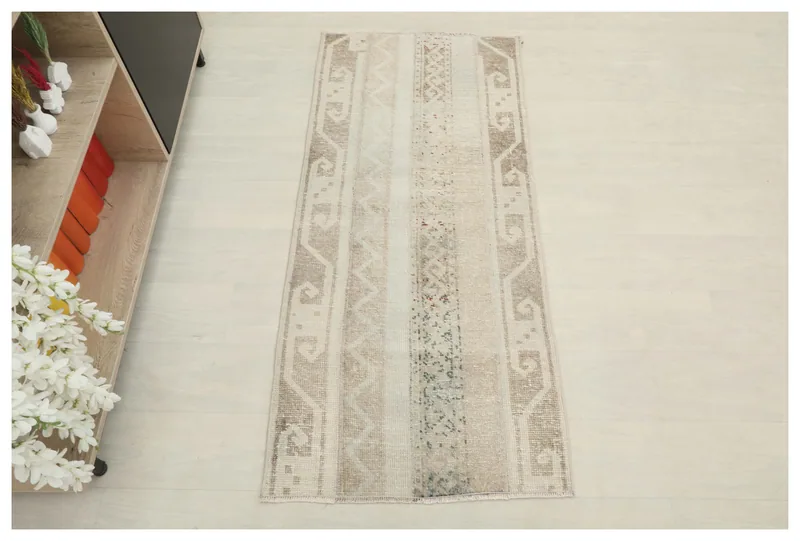 Full top view of the beige striped tribal vintage Anatolian rug on a white background.