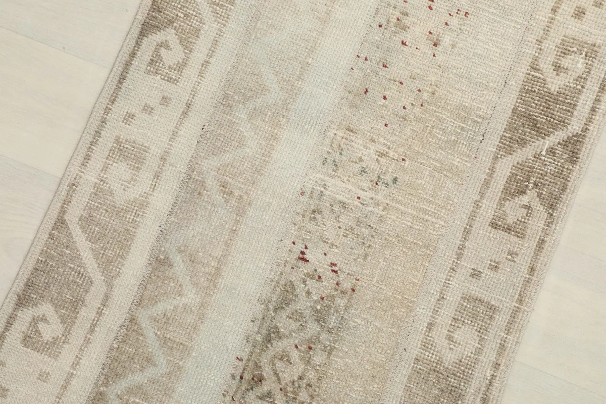 Close-up detail of the rug's central striped bands, showing subtle color variations and motifs.