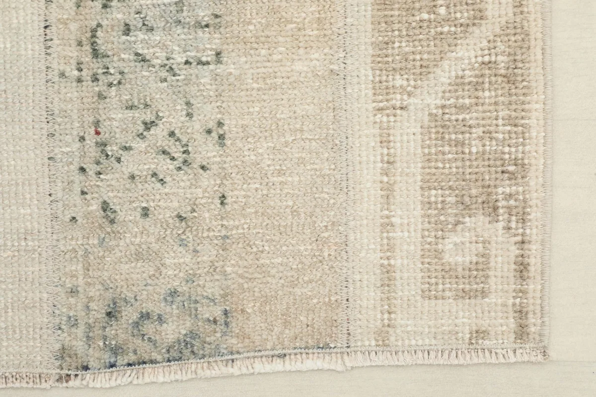 Close-up of the rug's edge and fringe, revealing the hand-knotted construction and cotton foundation.