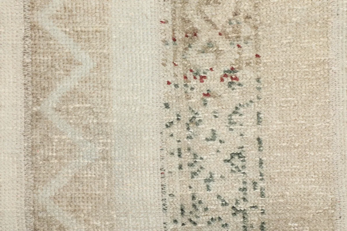 Macro view of the low wool pile, showing individual knots and the texture of the vintage rug.