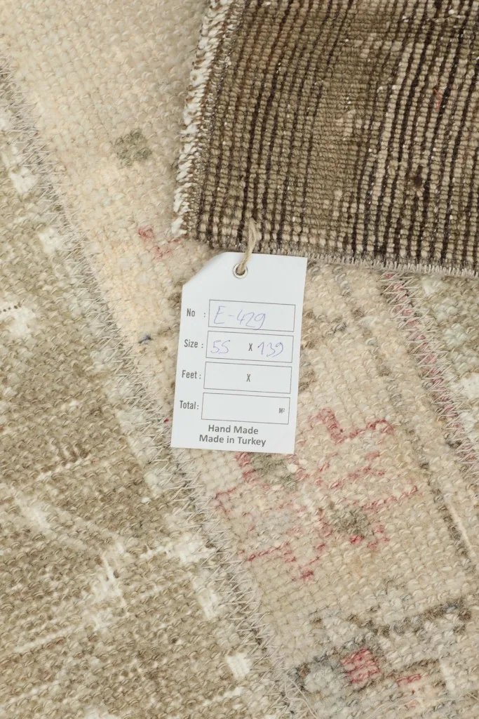 Close-up of the care tag attached to the rug, indicating its origin and hand-made quality