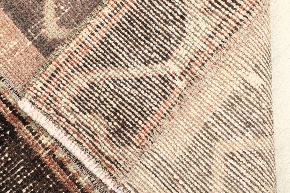 View of the rug's underside, showing the hand-knotted cotton foundation and wool pile