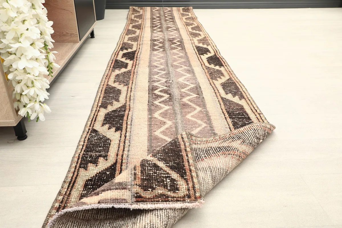 The runner rug partially folded, revealing the texture and thickness of the hand-knotted wool