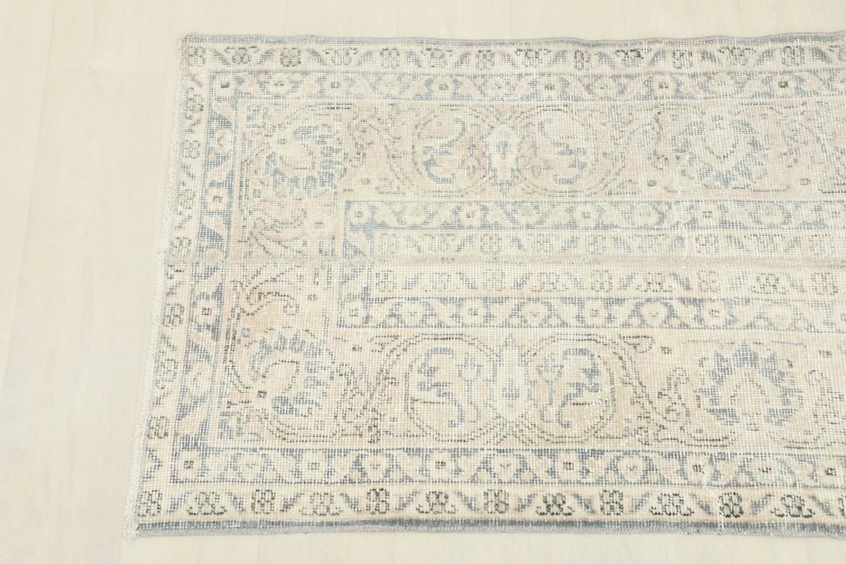 Corner detail of the runner rug, showing the intricate hand-knotted motifs and subtle color variations.