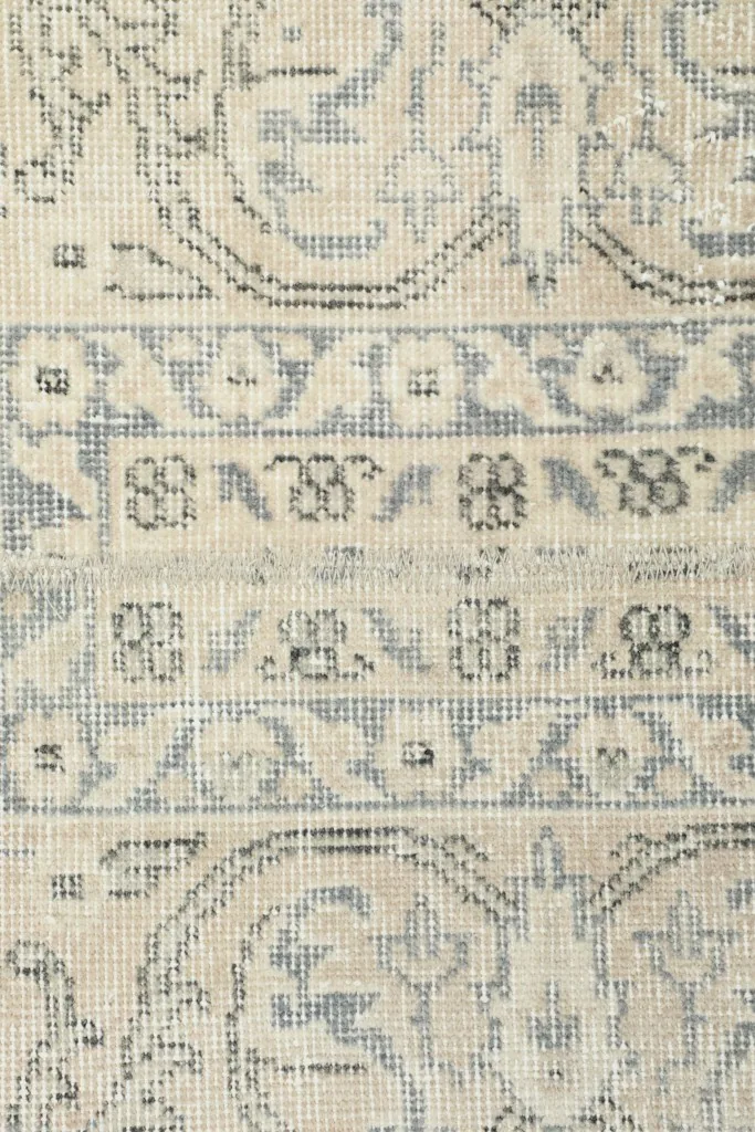 Very close view of the low wool pile and visible knotting, revealing the vintage wear and texture.