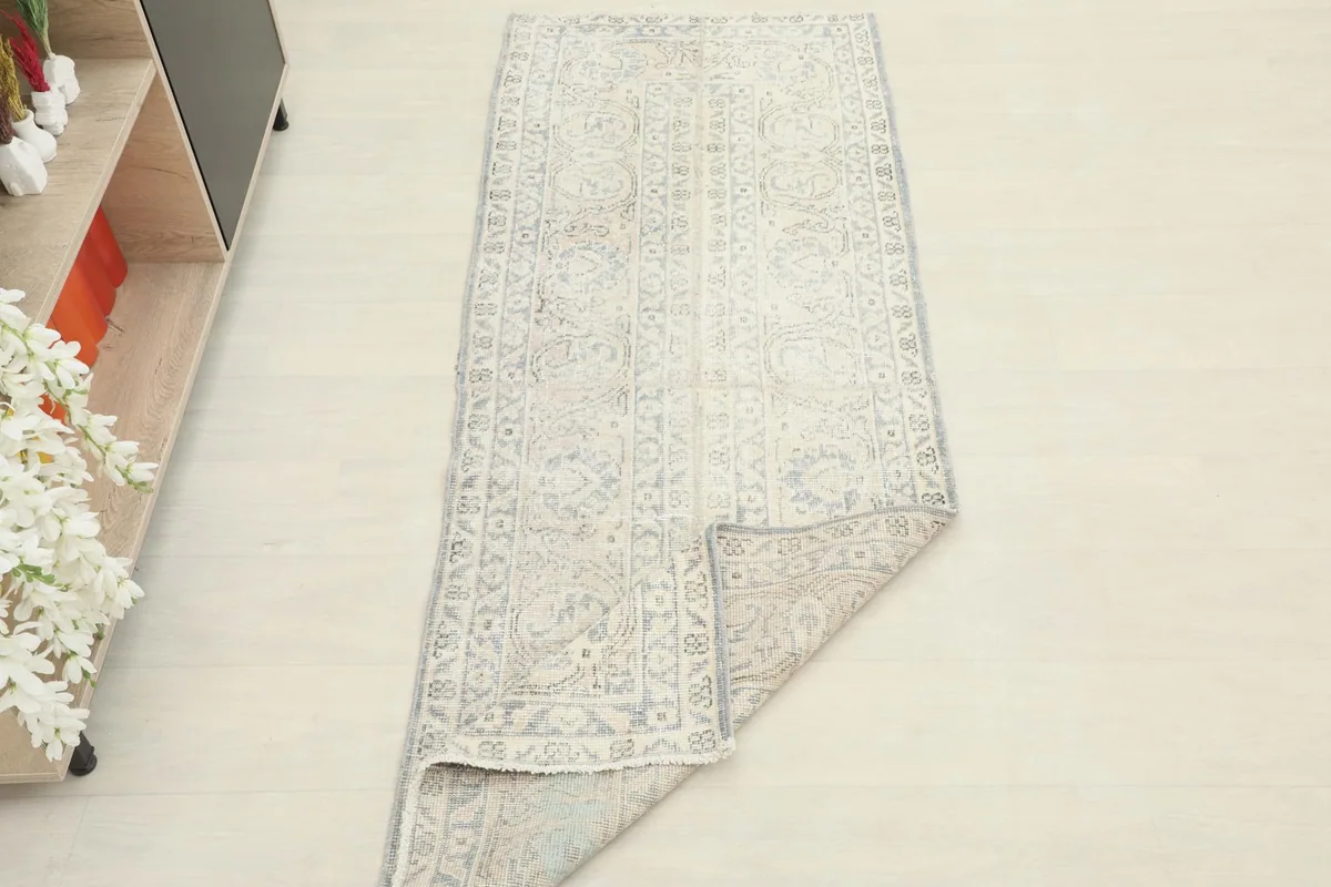 View of the runner rug with one corner folded back, showing the cotton foundation and overall flexibility.