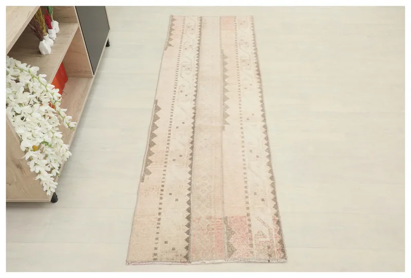 Full top view of the beige and rose striped vintage runner rug on a white background