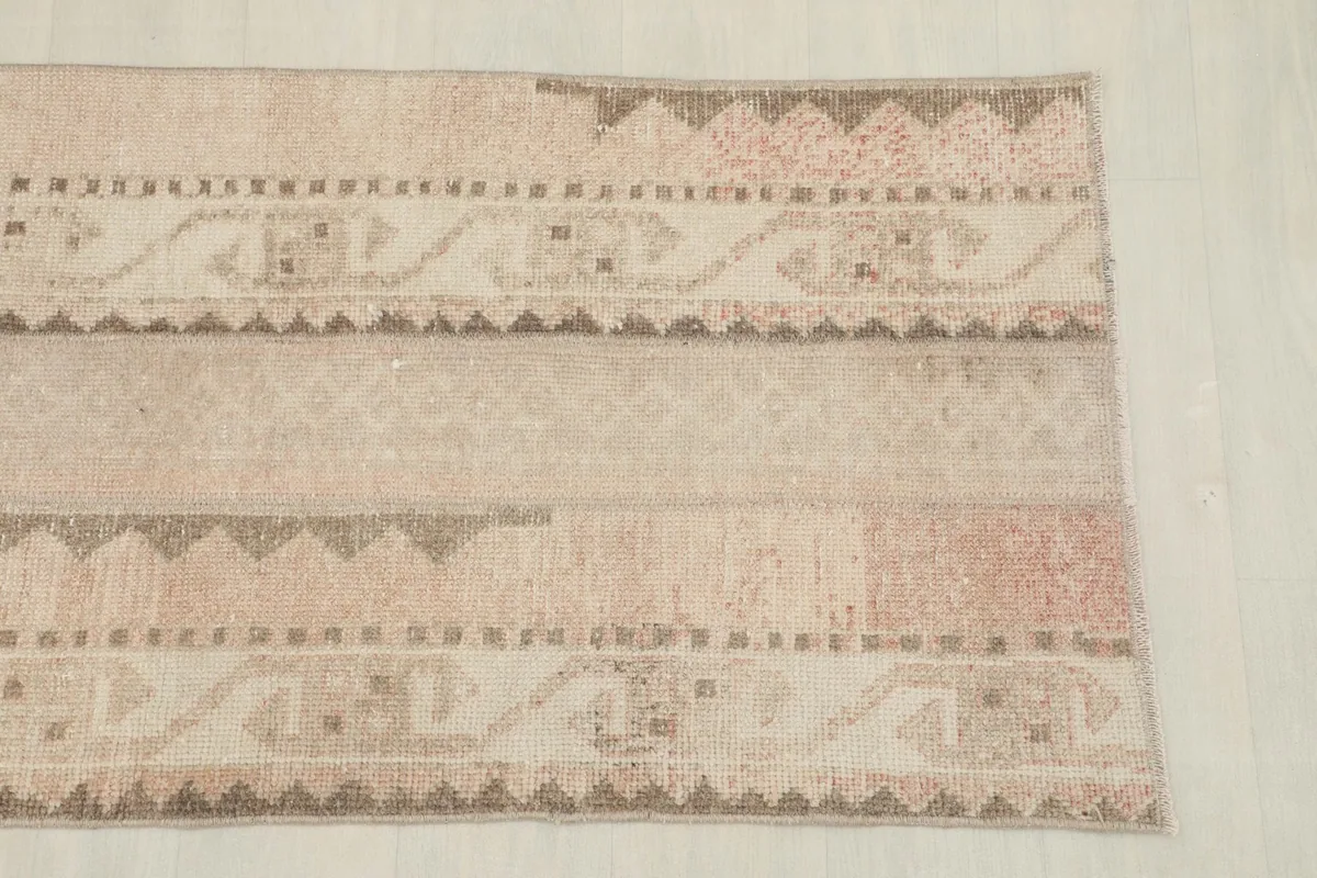 Detailed view of one end of the runner, highlighting the varied patterns and beige tones