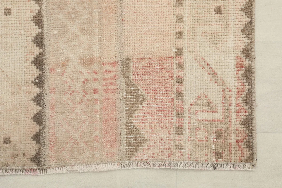 Detail of the edge and fringe of the rug, showing the blend of colors and slight wear