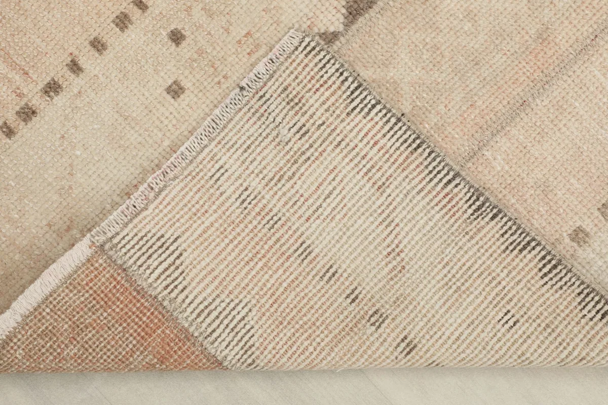 View of the back of the hand-knotted wool rug, revealing its cotton foundation