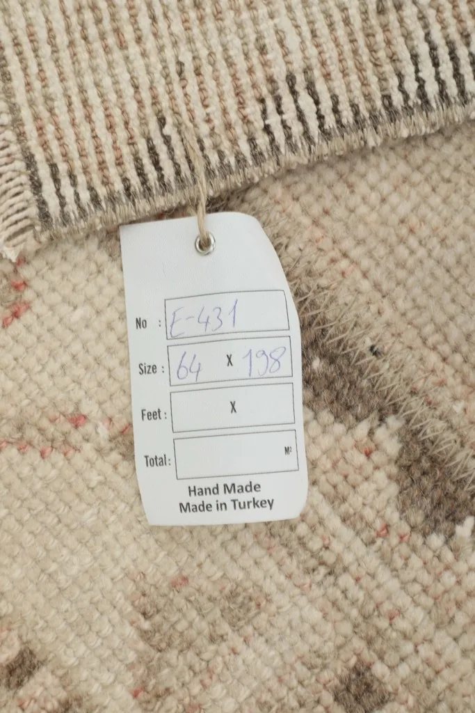 Close-up of the rug's tag, indicating its handmade origin in Turkey and size in cm