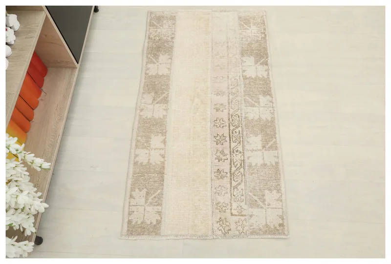 Full overhead view of the 2'2" x 4'0" cream and tan patchwork vintage Anatolian rug.