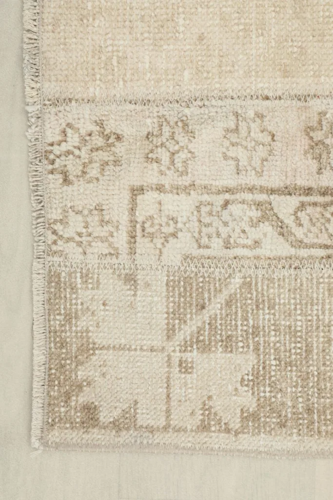 Detail of the rug's edge, showing the hand-knotted wool pile and cotton foundation.
