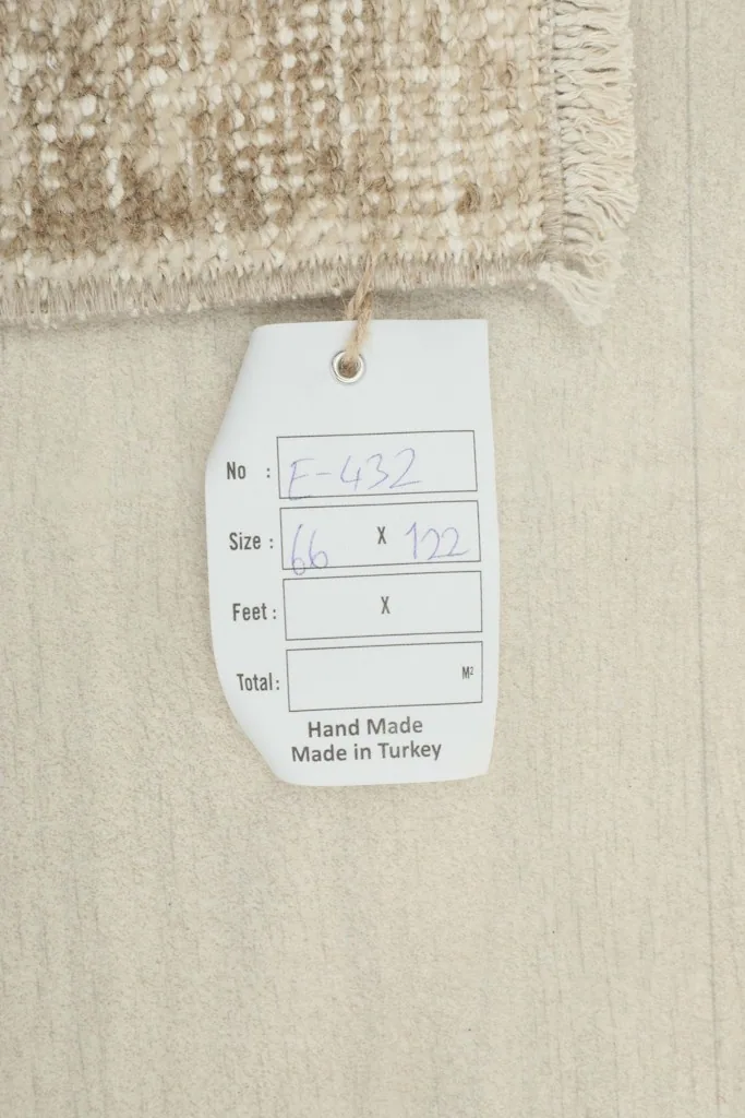 Tag displaying the rug's dimensions in centimeters (66 x 122 cm) and its handmade origin.