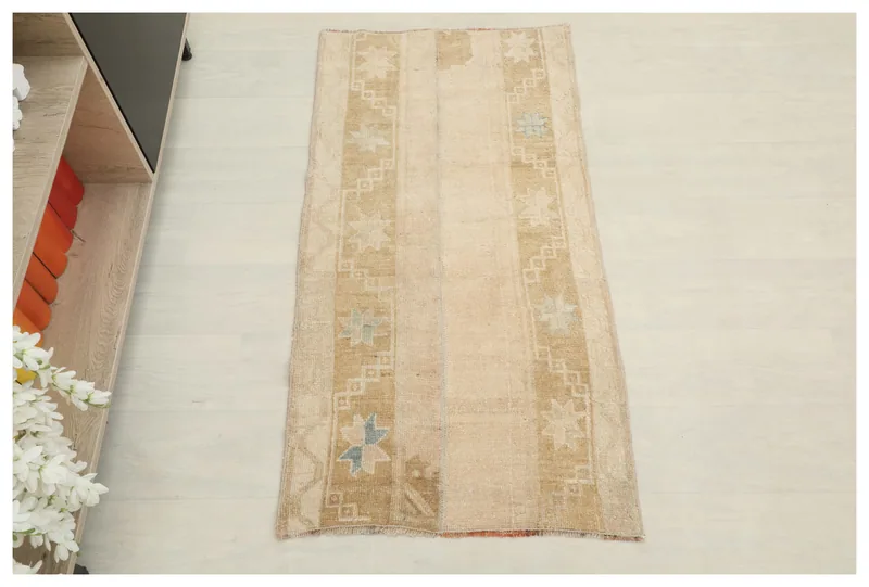 Full top view of the beige and tan geometric tribal vintage Anatolian rug on a white background.