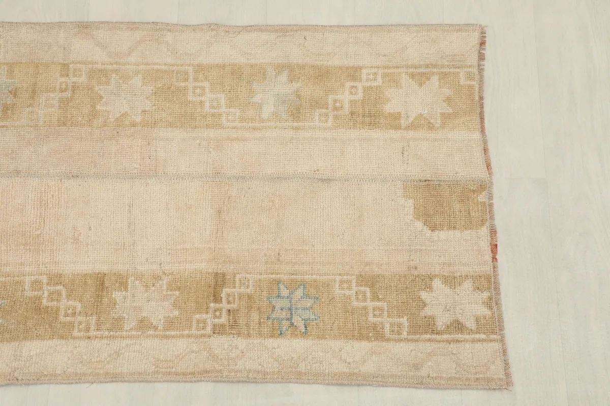 Detailed overhead view of one end of the rug, highlighting the worn texture and tribal designs.