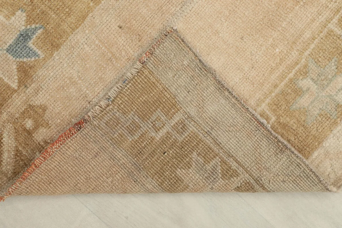 Corner folded back to show the cotton foundation and the reverse side of the hand-knotted weave.