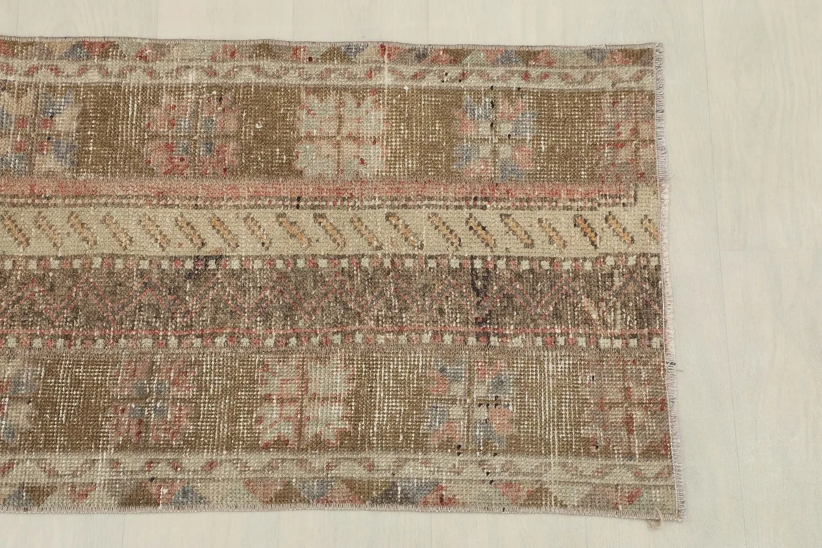Detail of the upper section of the rug, showing distinct geometric motifs and color variations.