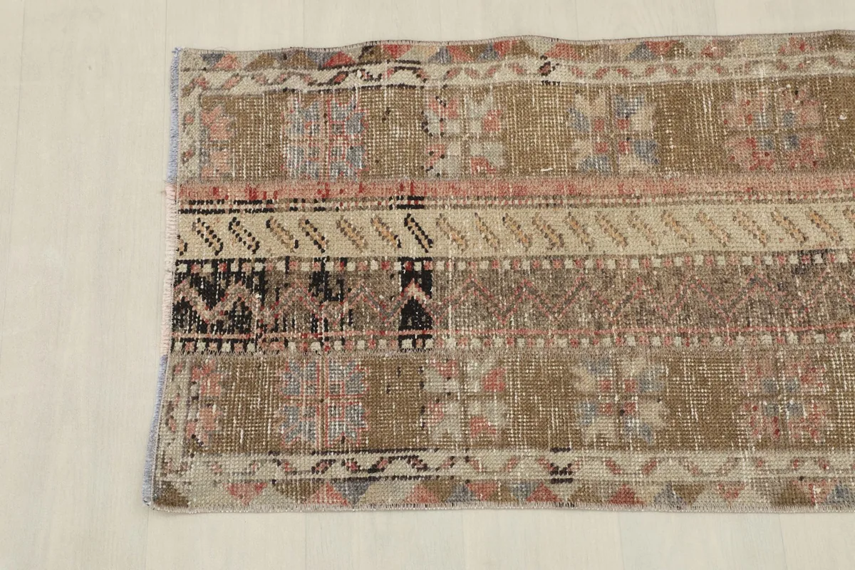 Detail of the lower section of the rug, featuring various geometric patterns and a black section.
