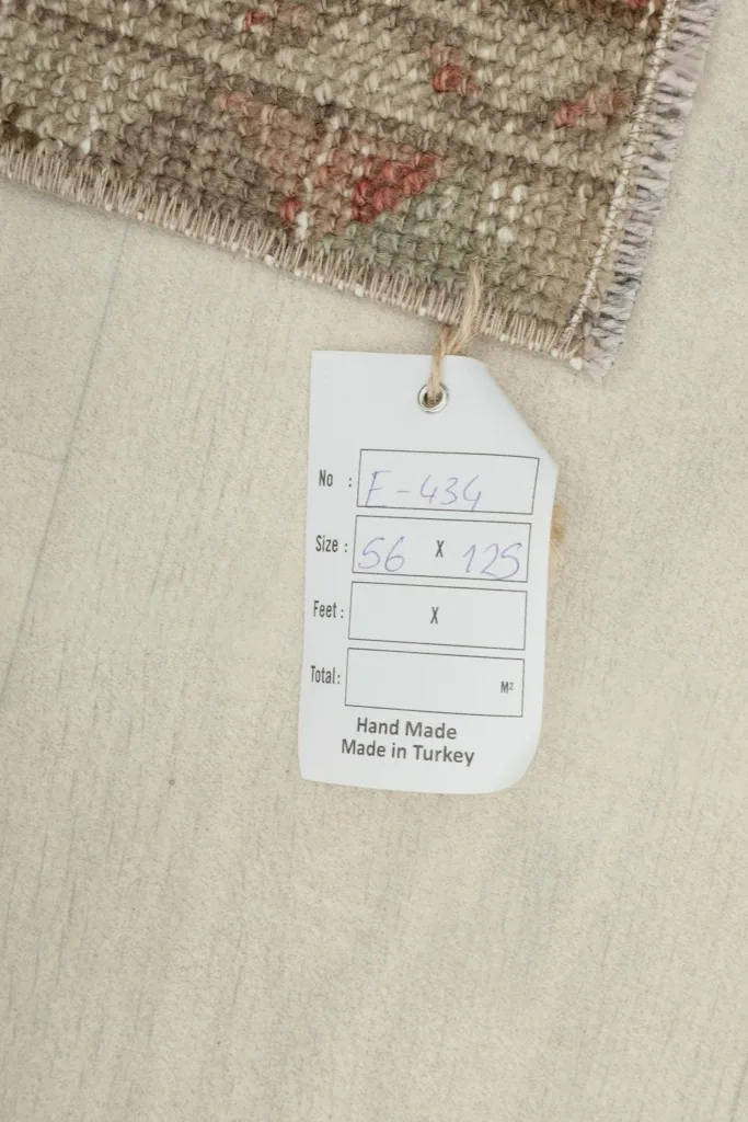 Tag displaying the rug's dimensions in centimeters and feet, confirming its hand-made origin in Turkey.