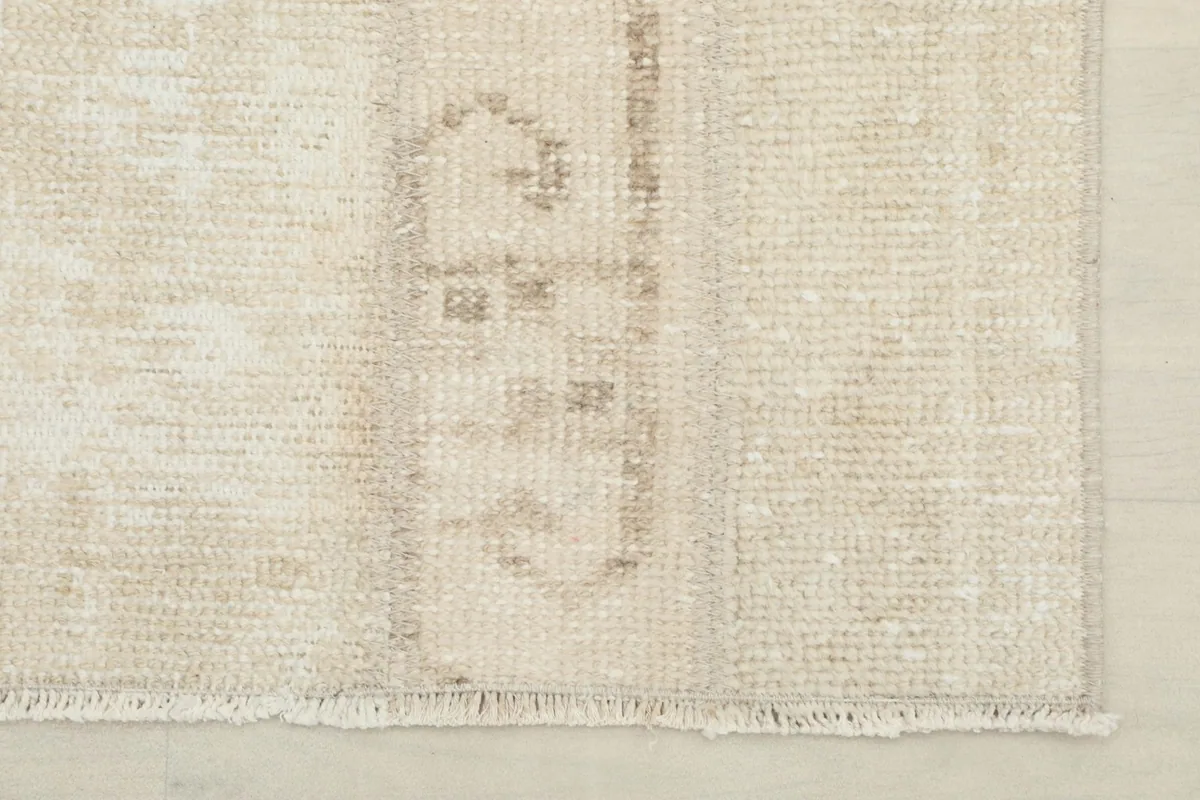 Close-up of the rug's end, showing the short fringe and a section of the pattern