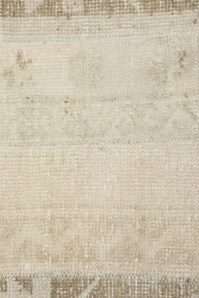 Overhead close-up showing the low pile and weave details of the beige and ivory sections.