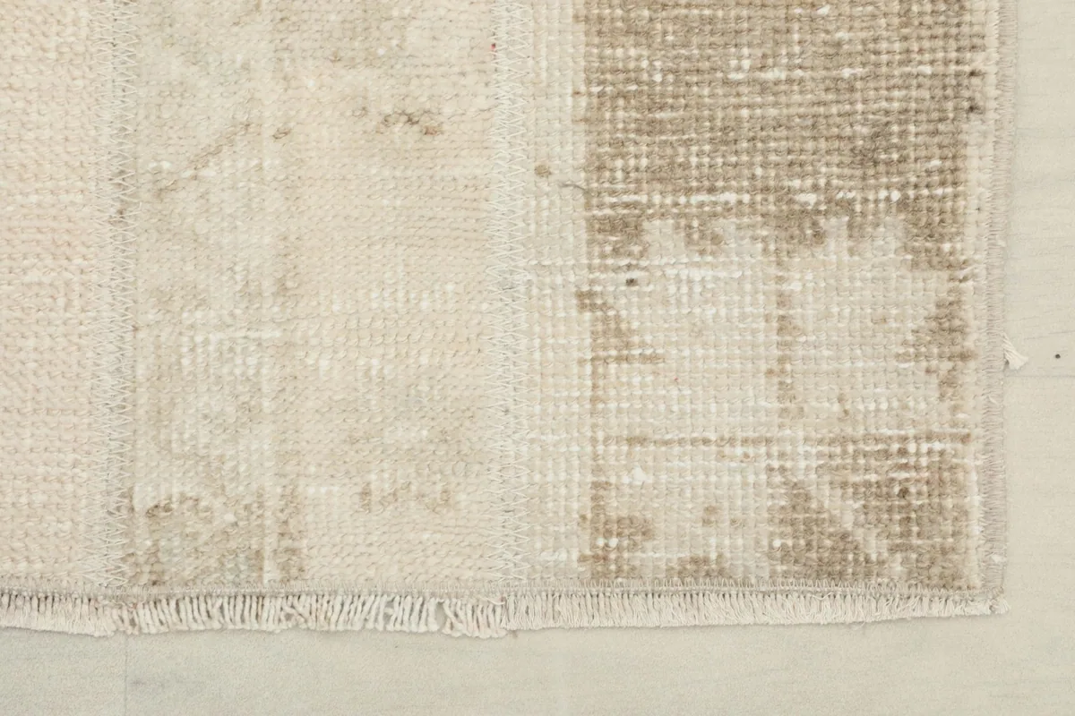 Corner detail showing the short fringe and the subtle wear on the rug's edge.