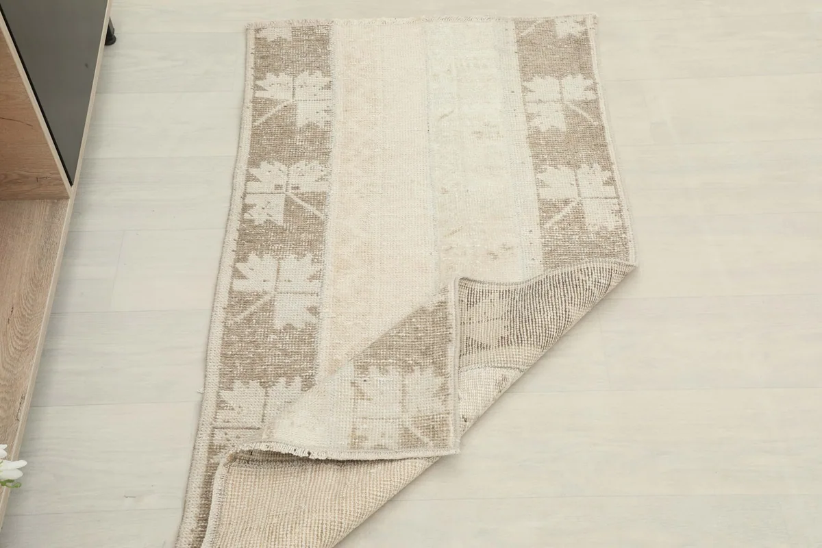 The vintage rug partially folded, showing its flexibility and full design.