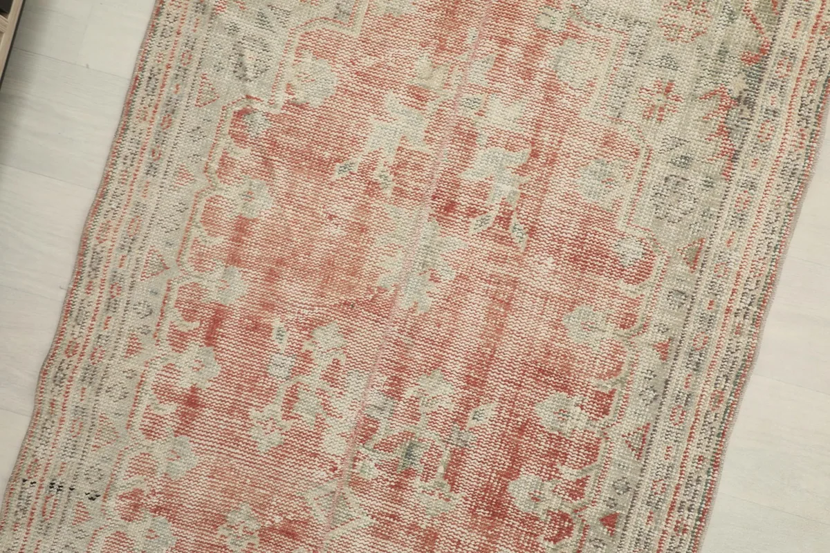 Overhead shot focusing on the central design, revealing the worn low pile and vintage character.
