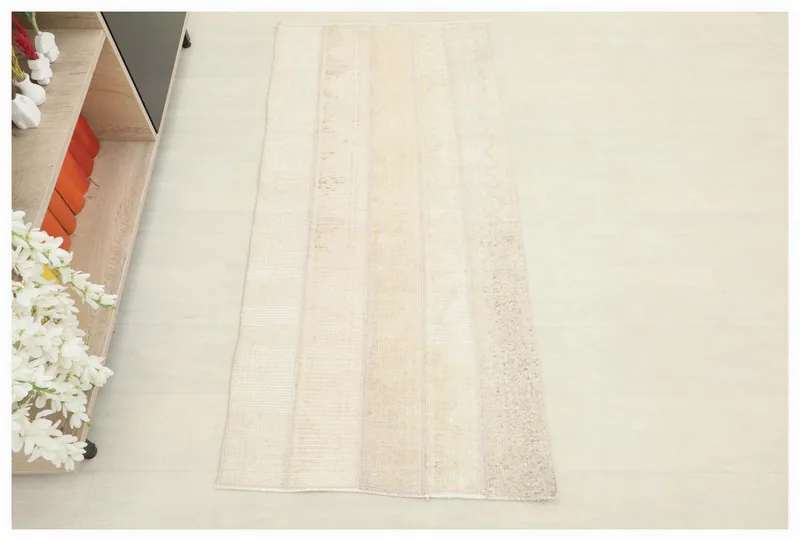 Full top view of the 2'3" x 4'9" cream and beige patchwork area rug on a white background