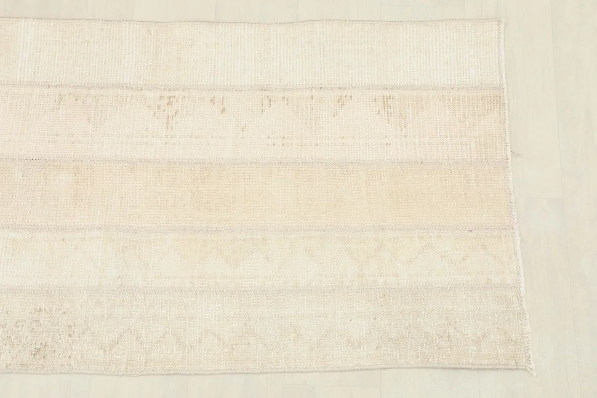 Close-up detail of the rug's surface, highlighting the stitched patchwork sections and subtle patterns