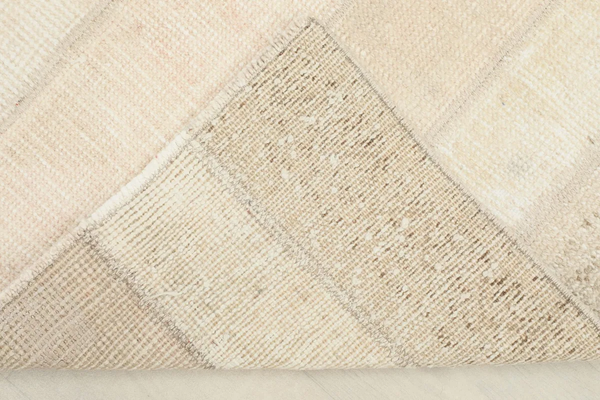 View of the underside of the rug, revealing the cotton foundation and the hand-knotted construction