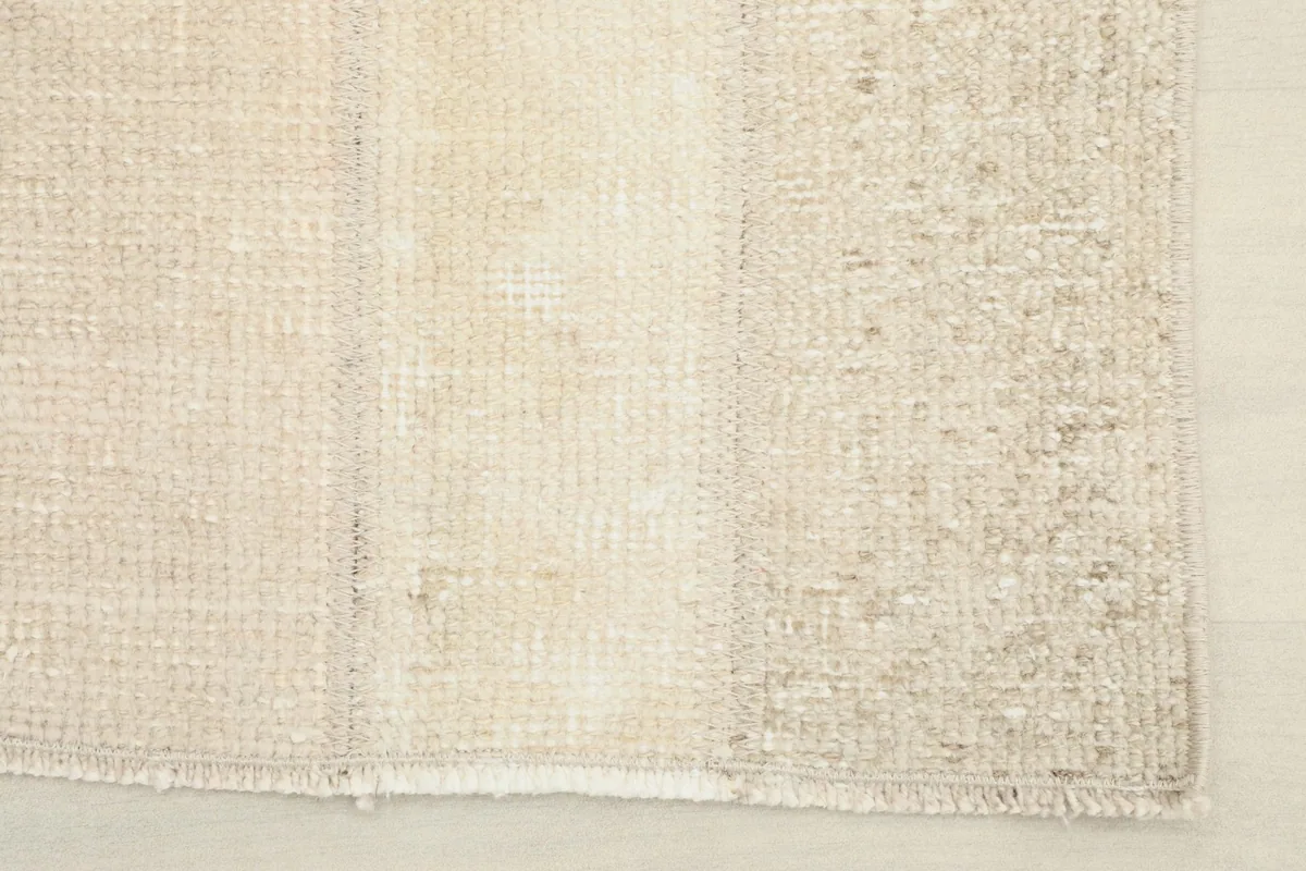 Close-up of one end of the rug, showing the short, neat fringes and the construction of the patchwork