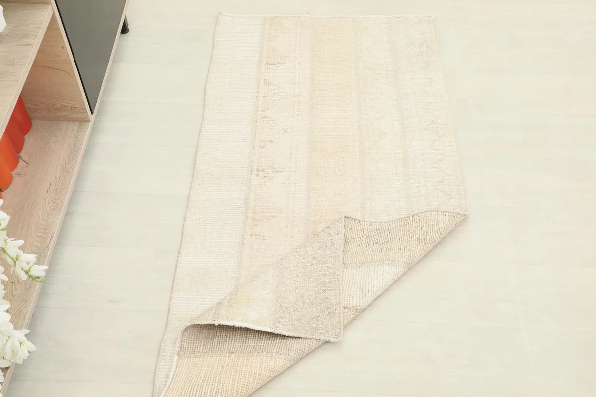 The rug partially folded, showcasing its flexibility and the reverse side with its patchwork stitching