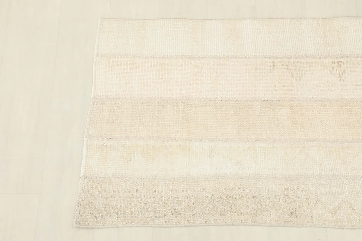 Overhead view focusing on the upper part of the rug, revealing the different textures and shades of beige