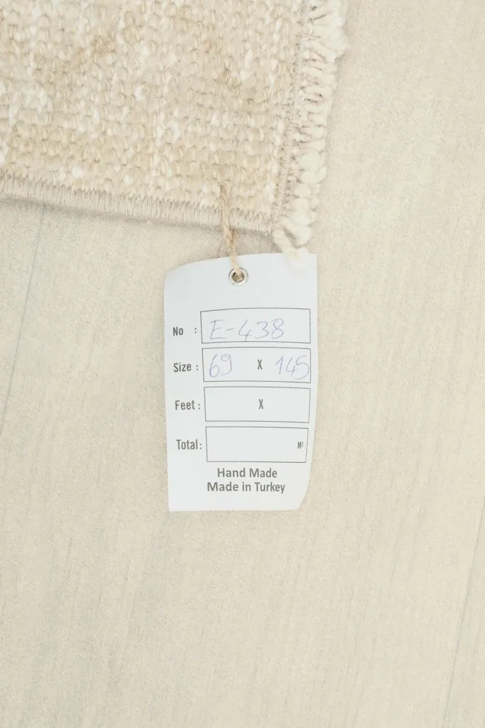 Close-up of the rug's label, indicating its handmade origin from Turkey and dimensions