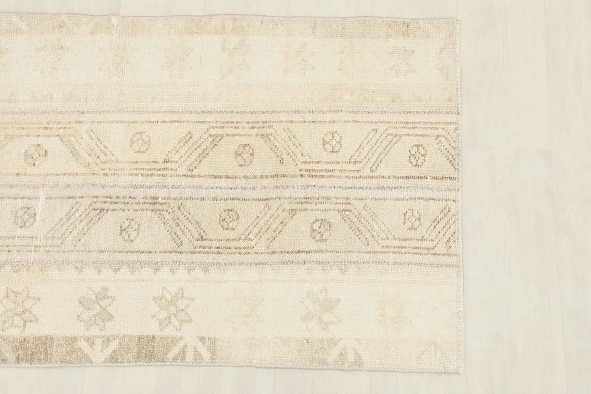 Close-up of the rug's beige field and tan geometric patterns