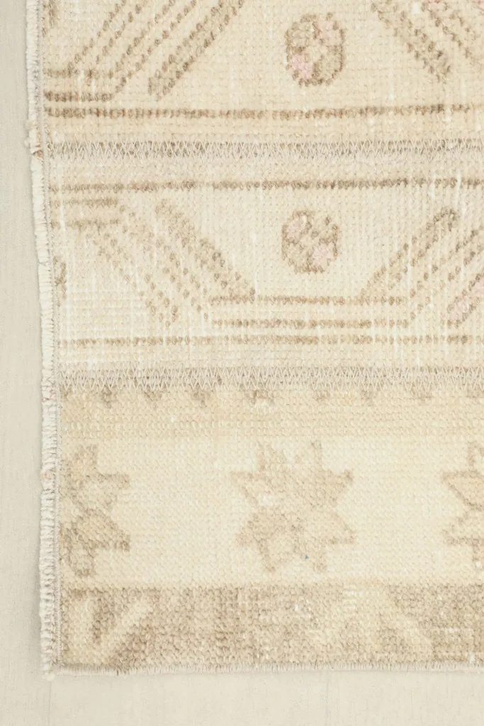 Corner detail of the rug, showing the edge finish and patterns