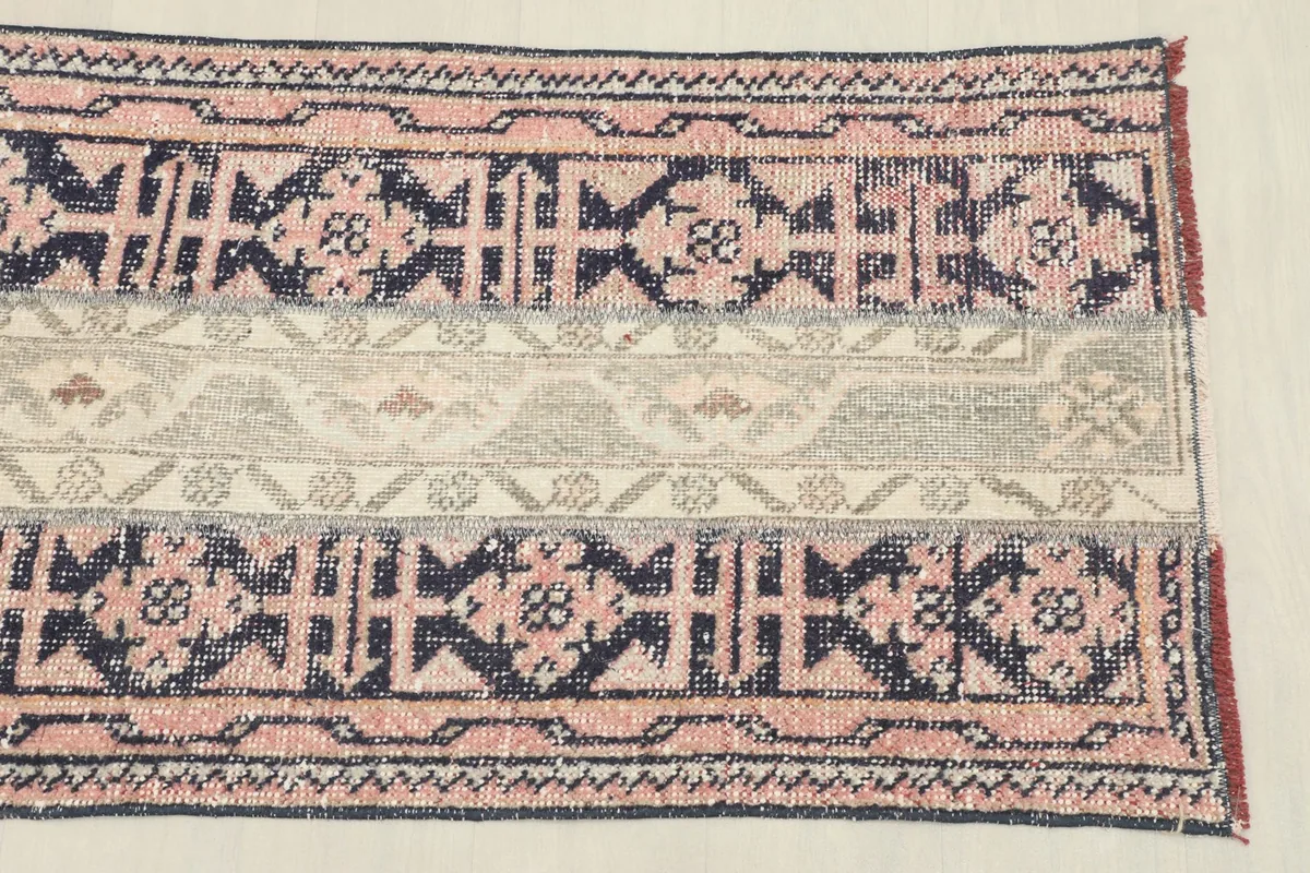 Close-up of the rug's center, highlighting the striped sections and varied geometric motifs.