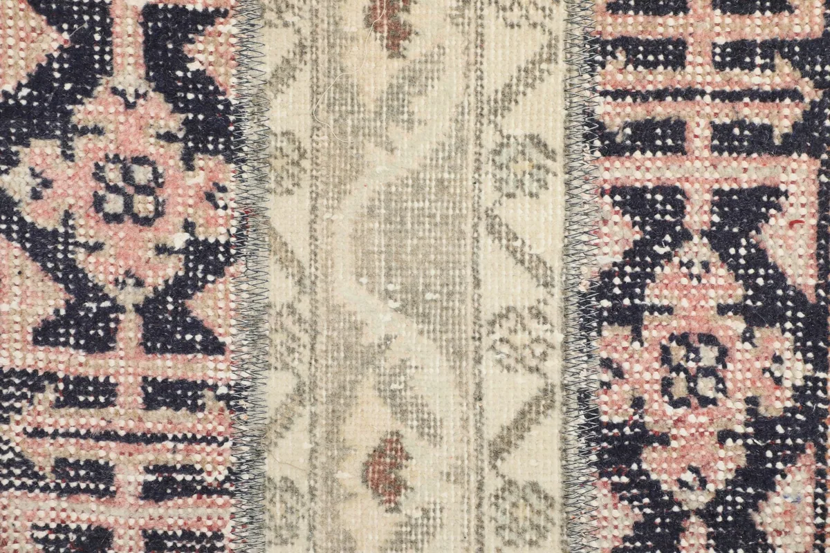 Extreme close-up of the hand-knotted wool pile and intricate tribal motifs.
