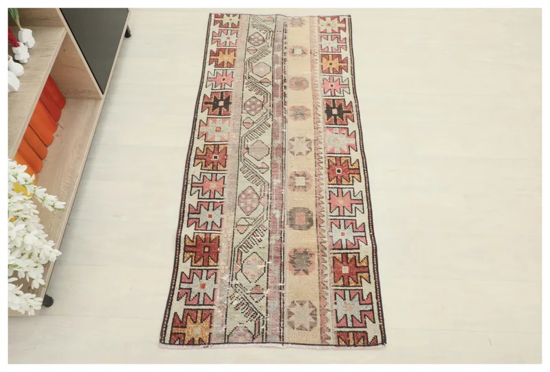 Full top view of the beige geometric tribal rug on a white background