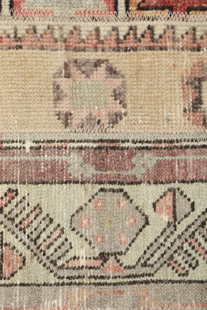 Close view of the low wool pile and intricate knotting of the vintage rug