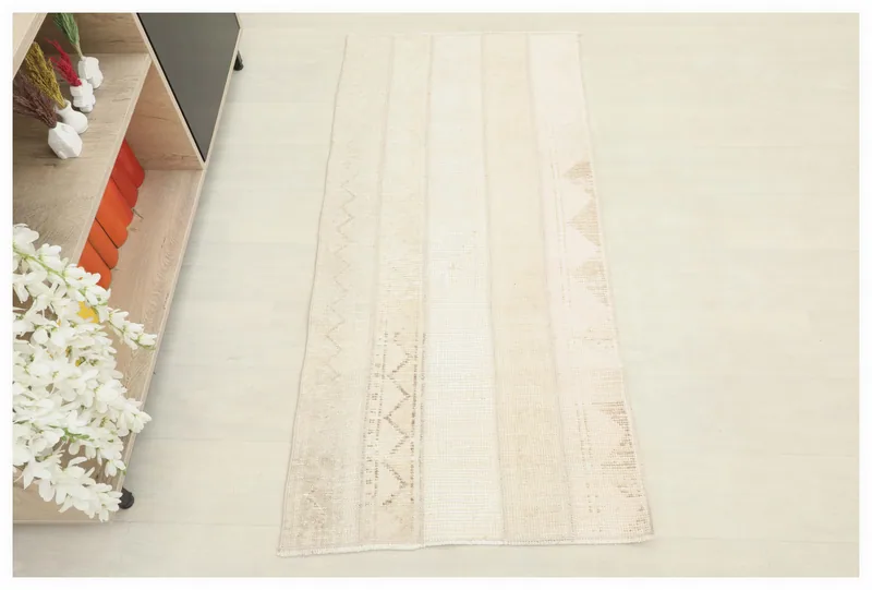 Full top view of the 2x5 beige geometric patchwork rug on a white background