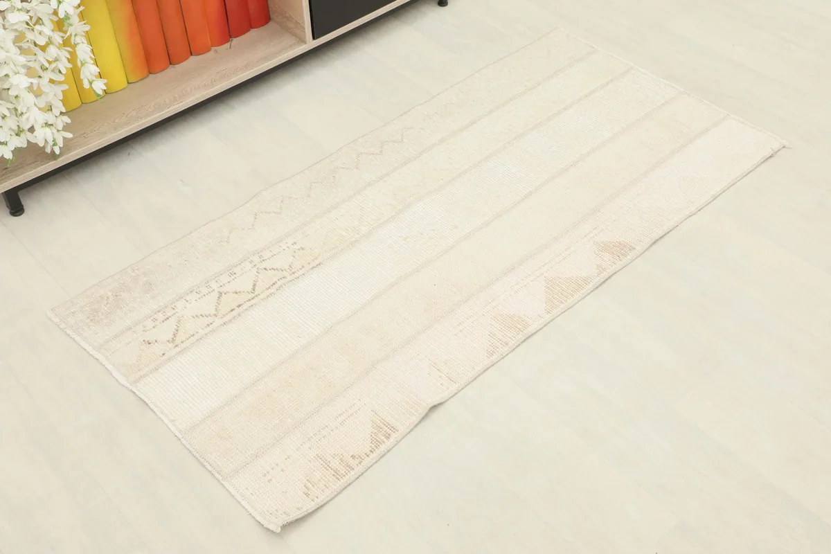 Angled overhead view of the beige and tan vintage area rug