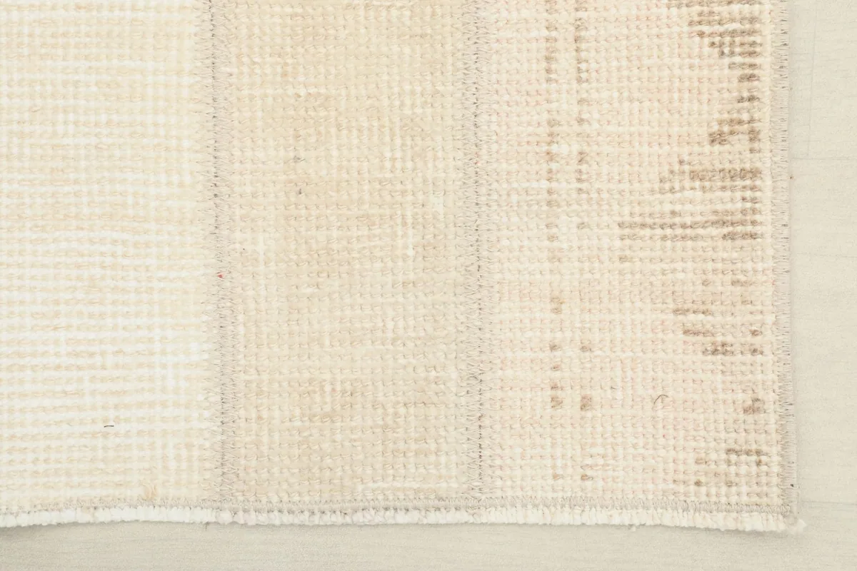 View of the low wool pile and edge finishing of the hand-knotted rug