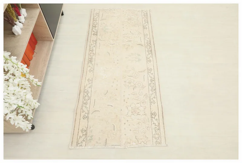 Full top view of the ivory vintage Anatolian rug with subtle floral and geometric patterns
