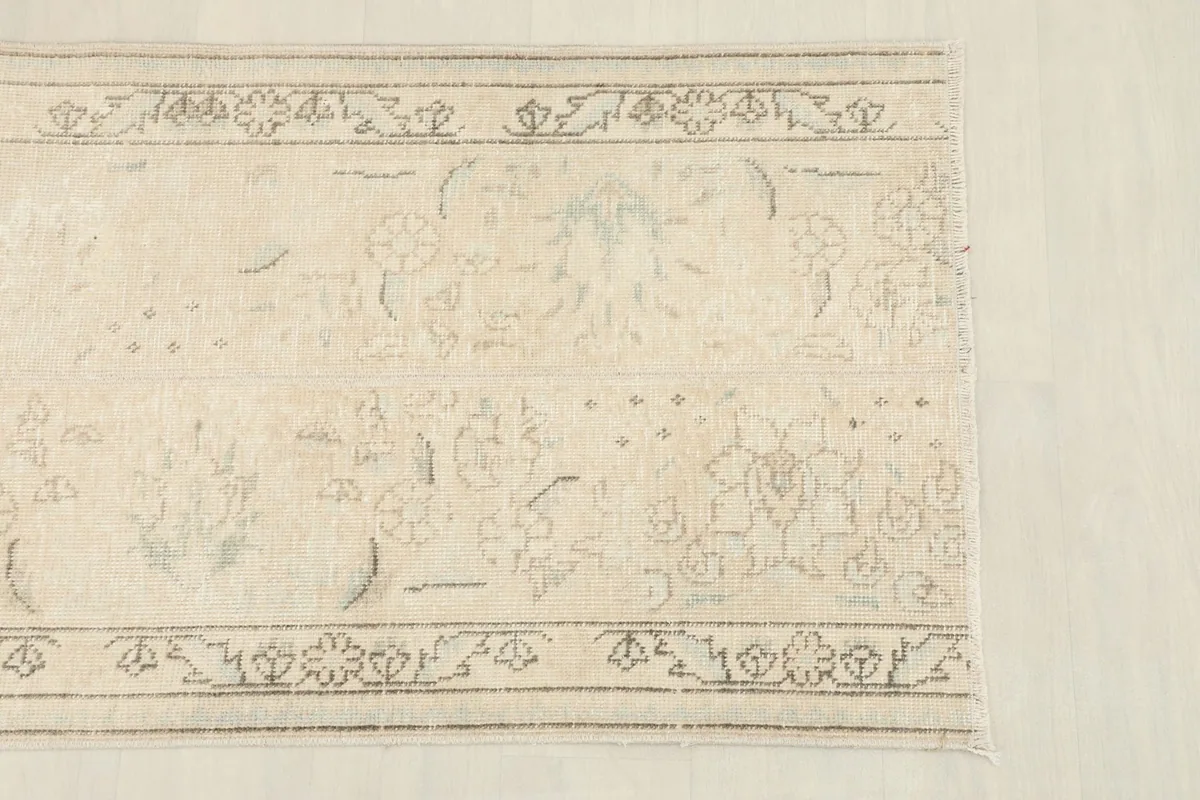 Close-up of the rug's central design and border, highlighting the muted colors and patterns