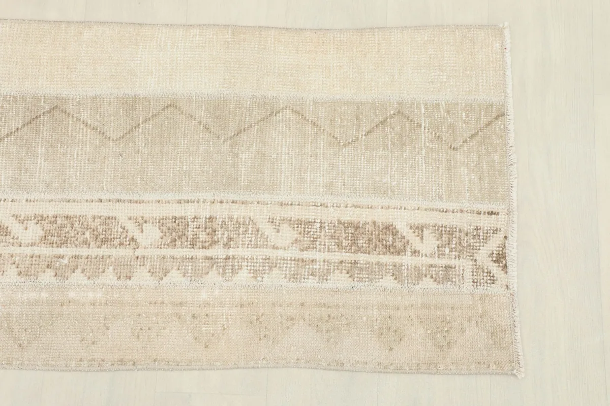 Detail view of one end of the runner, highlighting the varied beige tones and brown patterns.