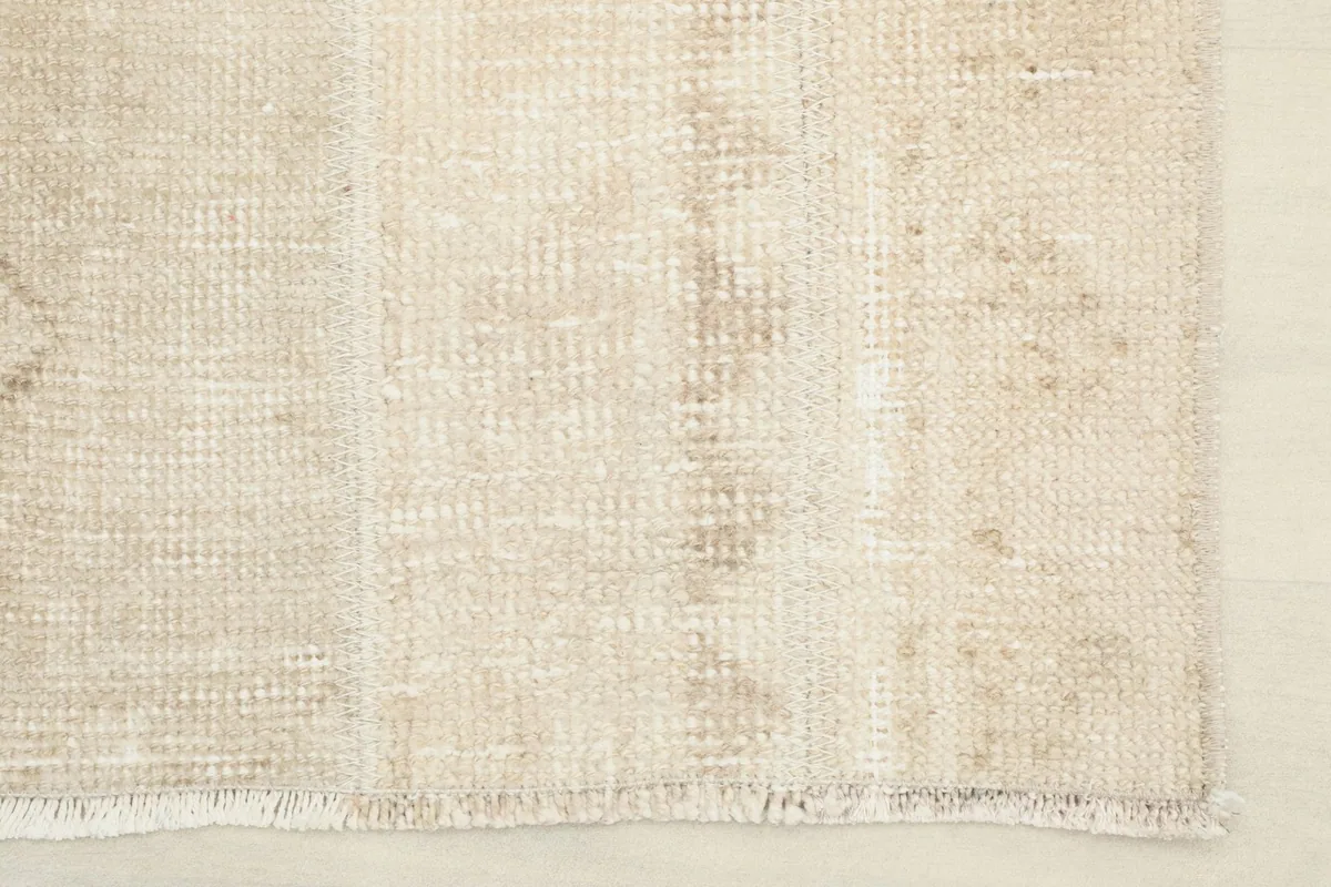 Close-up of the short, natural fringe and edge finishing of the vintage runner.